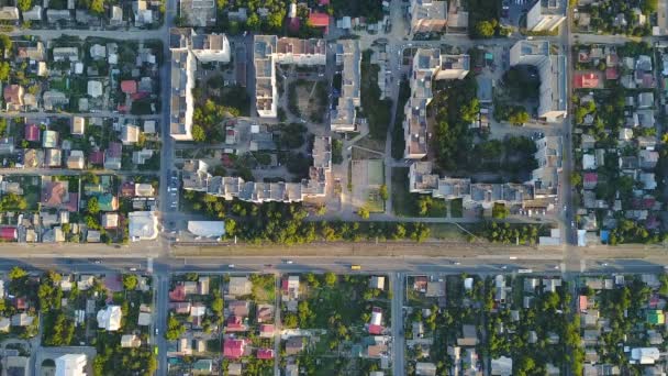 Blick aus großer Höhe auf die Stadt am Tag. Autos fahren auf Straßen. viele verschiedene Häuser im Erdgeschoss. — Stockvideo