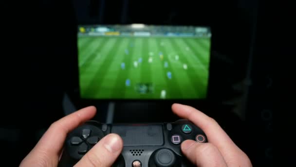 Menselijke handen worden gespeeld op de joystick op de achtergrond van het Tv. virtuele voetbalspel. Speler is boos op computerspelletjes. — Stockvideo