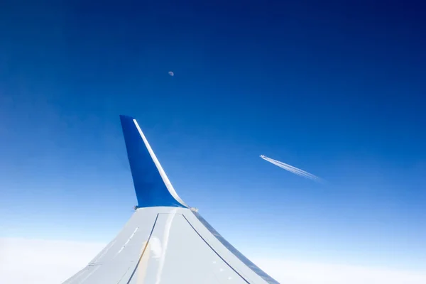 Kanat ve başka bir uçak tarafından uzaktan uçan uçak penceresinden görüntülemek.