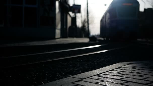 Kameranın önüne geçer ve güneş ışığı gizlemektedir şehir tramvay siluetleri. — Stok video