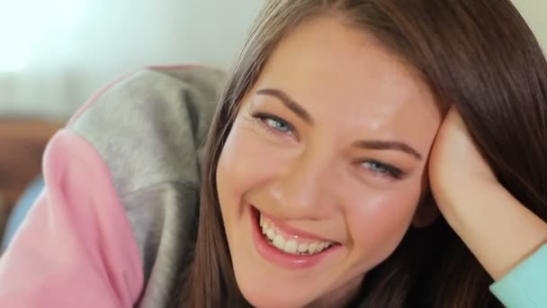 A very beautiful brunette with blue eyes looks at the camera and laughs cheerfully. — Stock Video