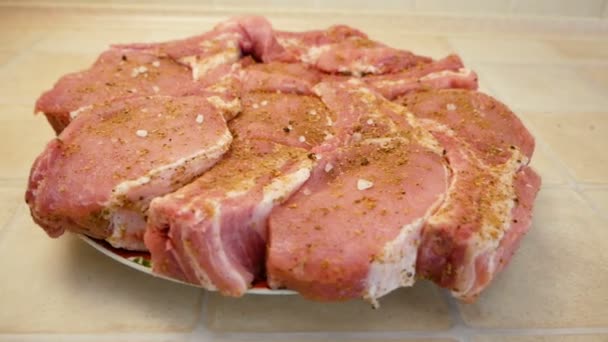 Die Kamera dreht sich um rohe Fleischstücke, gewürzt und gesalzen. Kochstück zum Grillen von Steaks. — Stockvideo