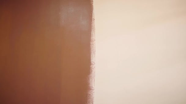 Rouleau de peinture. Brosser un mur nu blanc de haut en bas. Couleur marron. Concept de design. Poignée longue . — Video