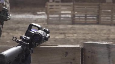 Kasklı, kimliği belirsiz bir askerin dürbünle silahını dolduruşunu. Askeri eğitim sahası. Açık havada. Savaş.