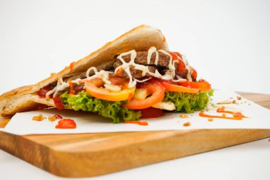 Beyaz arkaplanda doğranan tahtada Doner kebabı yan görünümü