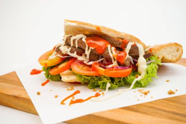 Beyaz arkaplanda doğranan tahtada Doner kebabı yan görünümü