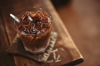Brown Coffee. Milk coffee glass on the brown wooden table background. Vietnamese coffee style