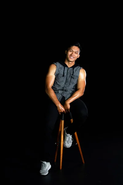 Retrato de un chico joven sonriente con músculo en el fondo negro. Hombres de moda — Foto de Stock