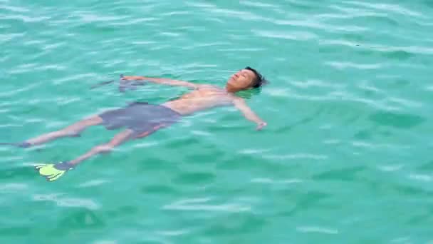Un uomo che galleggia sull'acqua senza giacca a vita. Godetevi le vacanze estive sulla spiaggia. Domenica 10 aprile 2019, Phu Quoc, Vietnam — Video Stock