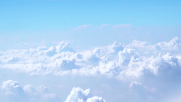 Όμορφα άσπρα σύννεφα επιπλέουν στον αέρα στον γαλάζιο ουρανό το πρωί μέσα από την θέα του αεροπλάνου — Αρχείο Βίντεο