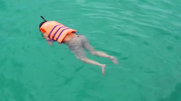 Lidé plavou po oceánu v záchranné vestě. Užijte si letní dovolenou na pláži. — Stock video