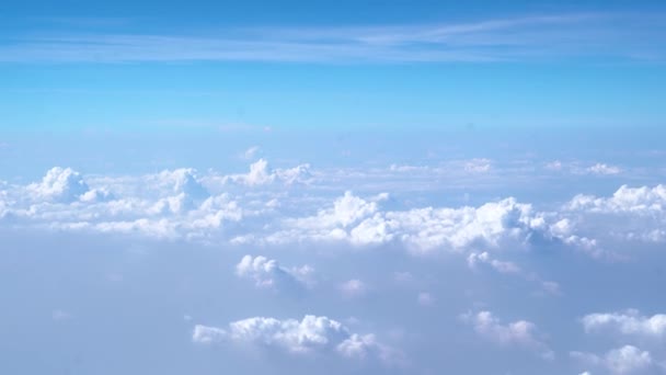 Lindas nuvens brancas flutuando no ar no céu azul pela manhã através da visão do avião — Vídeo de Stock