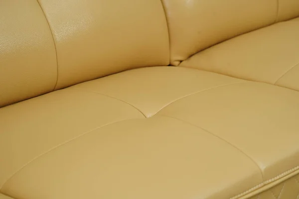 Желтый кожаный диван, крупные детали с пуговицами. Фотография в салоне мебели — стоковое фото