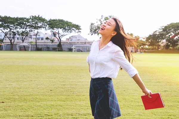 Jeune et jolie fille se sentant heureuse sur greenfield. Optimiste souriant asiatique étudiant libérer stress après avoir étudié — Photo