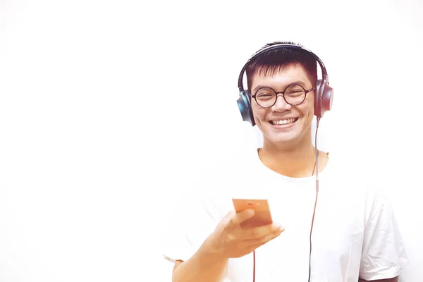 Optimistische knappe mannen die glimlachen en naar muziek luisteren met smartphone en koptelefoon op witte achtergrond — Stockfoto
