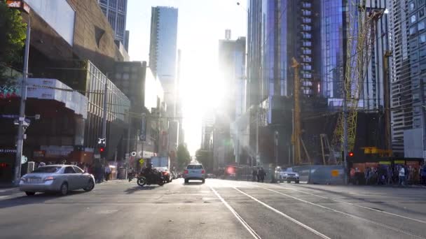 Escena de tráfico con coche y personas caminando y edificios en la ciudad urbana cerca del centro de Melbourne por la tarde. Melboure, Victoria, 25 de noviembre de 2019 — Vídeo de stock
