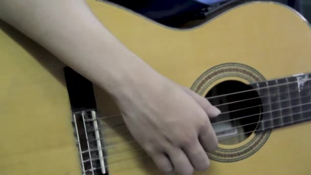 Jonge jongen leert gitaar spelen, zicht dicht bij zijn hand. Gitarist bewerken van gitaarsnaren. — Stockvideo