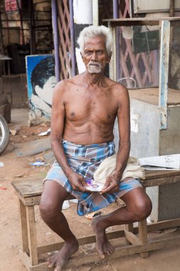 Editoryal açıklayıcı resim. Üzgün üst düzey Hintli adam gülümseyen portresi.