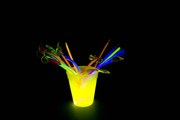 Флуоресцентное стекло желтого цвета со светящимися палочками — стоковое фото