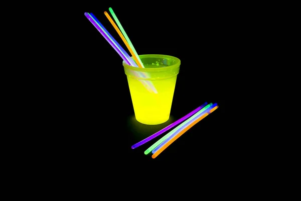 Флуоресцентное стекло желтого цвета со светящимися палочками — стоковое фото