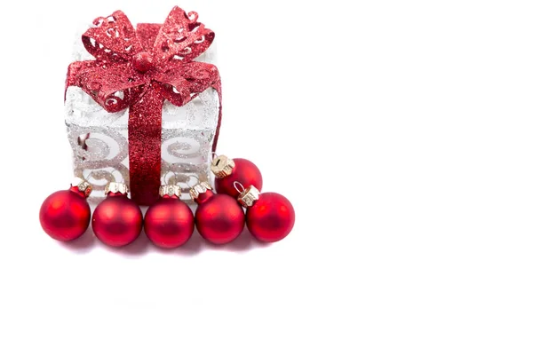 Рождественский подарок с красными шариками на белом фоне — стоковое фото