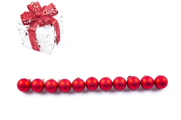 Cadeau de Noël avec des boules rouges sur fond blanc — Photo