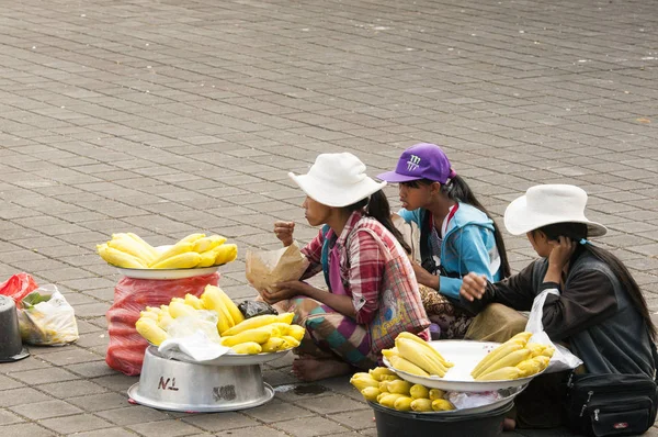 Illustrative editorial images. Woman saling sweet corn cobs in Bali, on the temple road — Stock Photo, Image