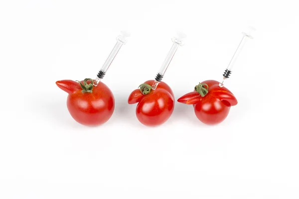 Tomatoes with deformation and defects on white background, with syringe. — Stock Photo, Image