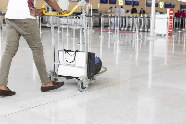 Airport luggage Trolley with suitcases, unidentified man woman walking in the airport, station, France.