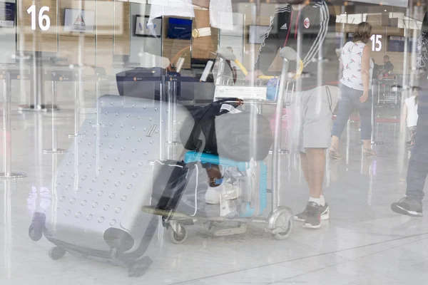 Documantary redaktionell bild. Flygplats bagage med resväskor, oidentifierad man kvinna promenader på flygplatsen, station. — Stockfoto