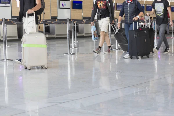Krótkometrażowego obrazu redakcji. Lotnisko bagażu z walizkami, niezidentyfikowany mężczyzna kobieta spaceru w na lotnisko, Dworzec. — Zdjęcie stockowe