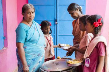 Belgesel yayın görüntü. Kimliği belirsiz womaen hizmet çocuklar öğle yemeği için açık kantinde