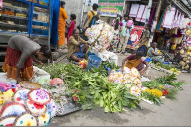 Belgesel yayın görüntü. Satıcı satış taze çiçekler, sebze, meyve, şemsiye Hindu Tanrı Ganesh yerel pazarda Ganesh ilk gününde korusun hayranları için