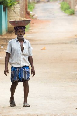 Belgesel yayın görüntü. Adamın kafası üzerinde büyük bir tabak içinde tuğla var