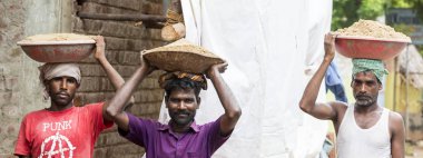 Belgesel yayın görüntü. Kafası üzerinde büyük bir tabak içinde tuğla erkekler var