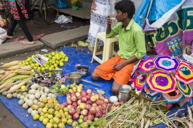 Belgesel yayın görüntü. Kimliği belirsiz bir Hint Tamil Nadu küçük kırsal köy pazarında meyve ve sebze onun dükkanında.