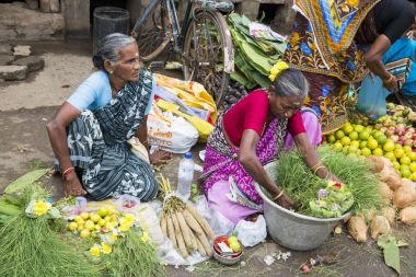 Belgesel yayın görüntü. Kimliği belirsiz bir Hint Tamil Nadu küçük kırsal köy pazarında meyve ve sebze onun dükkanında.