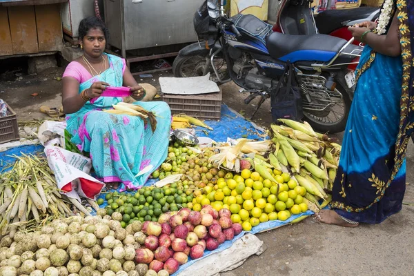 Belgesel yayın görüntü. Kimliği belirsiz bir Hint Tamil Nadu küçük kırsal köy pazarında meyve ve sebze onun dükkanında.