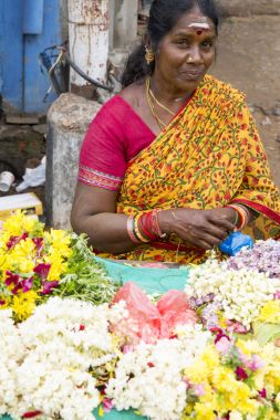 Documetary Editör görüntü. Kimliği belirsiz kadın satmak Hindistan'da açık ana Pazar çiçeklere oluşturma ipler.