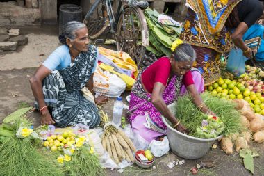 Belgesel yayın görüntü. Kimliği belirsiz bir Hint Tamil Nadu küçük kırsal köy pazarında meyve ve sebze onun dükkanında.