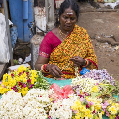 Documetary Editör görüntü. Kimliği belirsiz kadın satmak Hindistan'da açık ana Pazar çiçeklere oluşturma ipler.