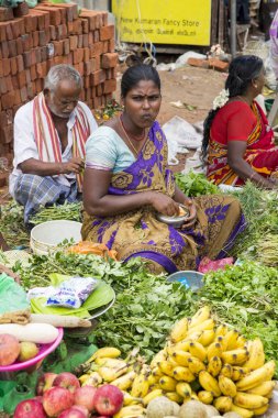 Belgesel yayın görüntü. Kimliği belirsiz bir Hint Tamil Nadu küçük kırsal köy pazarında meyve ve sebze onun dükkanında.