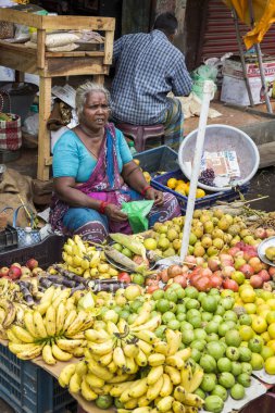 Belgesel yayın görüntü. Kimliği belirsiz bir Hint Tamil Nadu küçük kırsal köy pazarında meyve ve sebze onun dükkanında.