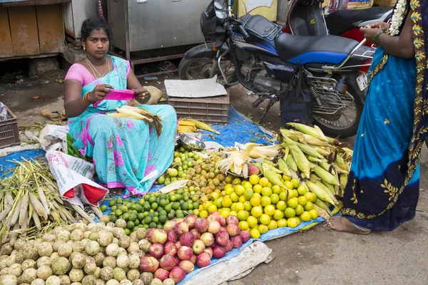 Belgesel yayın görüntü. Kimliği belirsiz bir Hint Tamil Nadu küçük kırsal köy pazarında meyve ve sebze onun dükkanında.