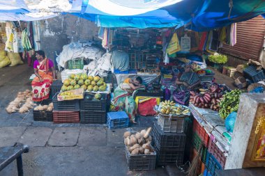 Belgesel yayın görüntü. Kimliği belirsiz bir Hint Tamil Nadu küçük kırsal köy pazarında meyve ve sebze onun dükkanında.