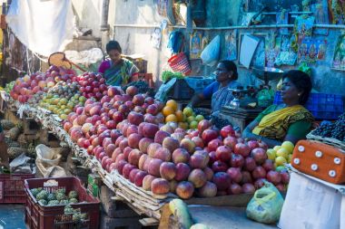 Belgesel yayın görüntü. Kimliği belirsiz bir Hint Tamil Nadu küçük kırsal köy pazarında meyve ve sebze onun dükkanında.