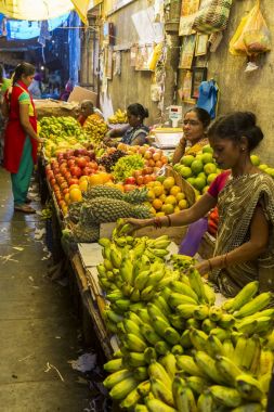 Belgesel yayın görüntü. Kimliği belirsiz bir Hint Tamil Nadu küçük kırsal köy pazarında meyve ve sebze onun dükkanında.