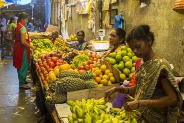 Belgesel yayın görüntü. Kimliği belirsiz bir Hint Tamil Nadu küçük kırsal köy pazarında meyve ve sebze onun dükkanında.
