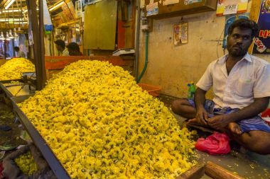 Documetary Editör görüntü. Kimliği belirsiz kadın satmak Hindistan'da açık ana Pazar çiçeklere oluşturma ipler.