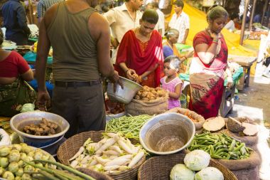 Belgesel yayın görüntü. Kimliği belirsiz bir Hint Tamil Nadu küçük kırsal köy pazarında meyve ve sebze onun dükkanında.